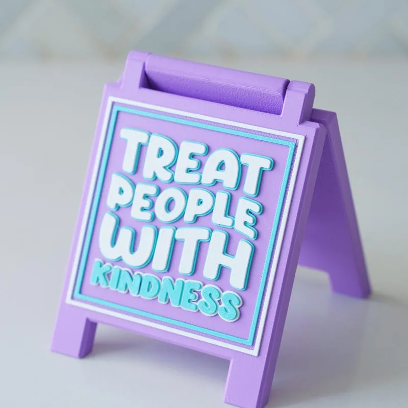 Lavender easel sign that reads Treat People With Kindness
